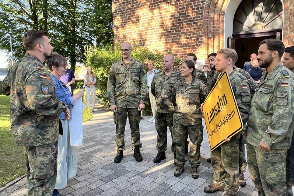Christiane Dunker-Kobza (2. v. lks.) überreichte stellvertretend für die Gewerbetreibenden aus Lensahn als Solidaritätszeichen die „gelbe Schleife“.