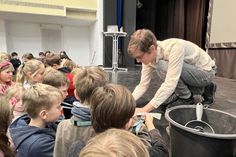 Referent Daniel Lenz von der Technischen Hochschule Lübeck beim Unterschreiben der Studentenausweise der Kinder.