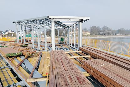 Das Stahlgerüst für den Wetterschutz, in dem ab Sommer auch Trauungen in Haffkrug stattfinden, steht bereits. Davor lagert das harte Bongossi-Holz, das als Bodenbelag verbaut wird.